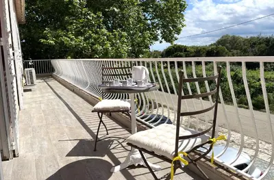 a table and two chairs on a porch with a table and a table at FURIANI Appartement avec Piscine dans Villa in Furiani