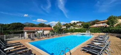 a swimming pool with lounge chairs next to a house at T2 Résidence Dolce & Vita B3 avec piscine in Propriano