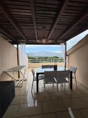 a kitchen with a table and some chairs in a room at Appartement dans résidence standing in Porto-Vecchio