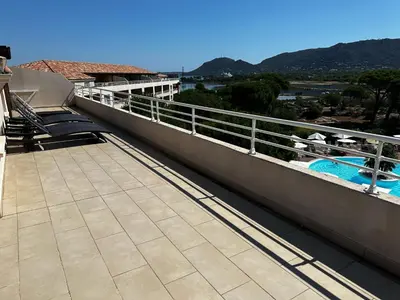a bedroom with a bed in a room with wooden ceilings at Appartement dans résidence standing in Porto-Vecchio