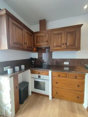 a kitchen with wooden cabinets and a white oven at Jolie location chez Philippe & Karine in Linguizzetta