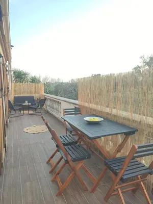 a patio with a table and chairs on a deck at Jolie location chez Philippe & Karine in Linguizzetta