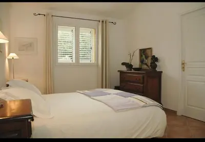 a bedroom with a bed and a dresser and a window at Villa Ysee in Porto-Vecchio