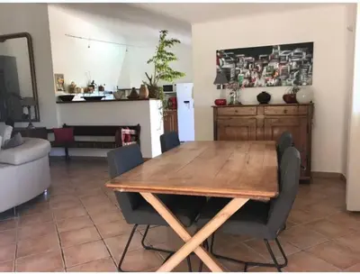a dining table and chairs in a living room at Villa Ysee in Porto-Vecchio