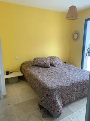 a bedroom with a bed in the corner of a room at Belle maison en Balagne in Zilia