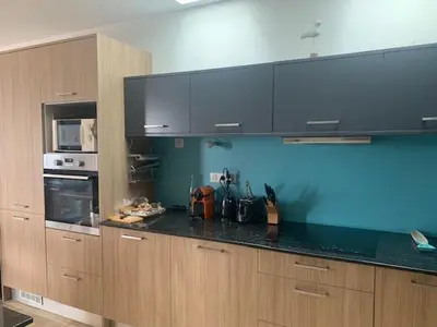 a kitchen with wooden cabinets and a black counter top at Belle maison en Balagne in Zilia