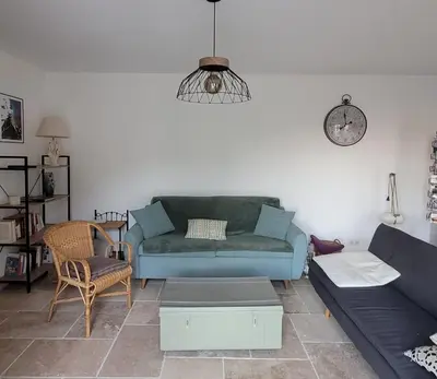 a living room with a blue couch and a chair at Belle maison en Balagne in Zilia