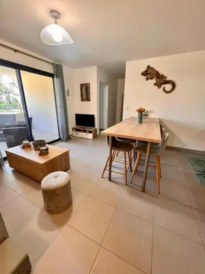 a living room with a table and a couch at Appartement A Maghjina proche port et centre ville in Porto-Vecchio