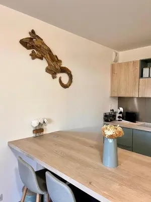 a kitchen with a table with a vase of flowers at Appartement A Maghjina proche port et centre ville in Porto-Vecchio