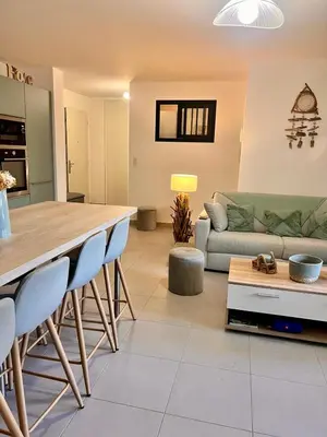 a kitchen and living room with a table and a couch at Appartement A Maghjina proche port et centre ville in Porto-Vecchio