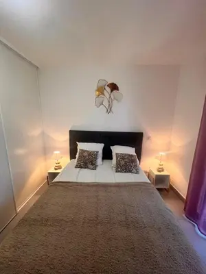 a bedroom with a large bed with two lamps at Appartement A Maghjina proche port et centre ville in Porto-Vecchio