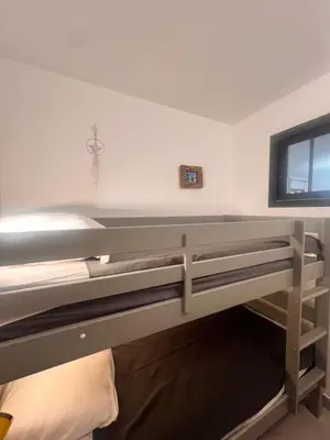 a bedroom with two bunk beds and a window at Appartement A Maghjina proche port et centre ville in Porto-Vecchio