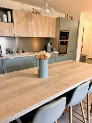 a kitchen with a wooden table with a vase of flowers on it at Appartement A Maghjina proche port et centre ville in Porto-Vecchio