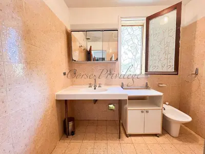 a bathroom with a sink and a toilet and a mirror at Maison Porticcio centre in Grosseto-Prugna