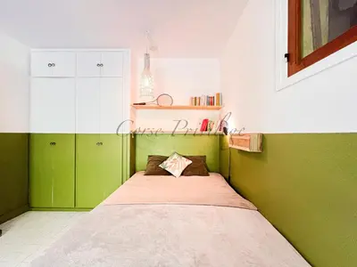 a small bedroom with green walls and a bed at Maison Porticcio centre in Grosseto-Prugna