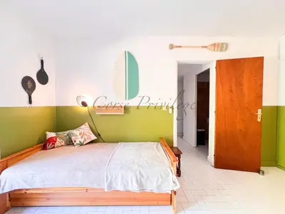 a bedroom with a bed with green and white walls at Maison Porticcio centre in Grosseto-Prugna