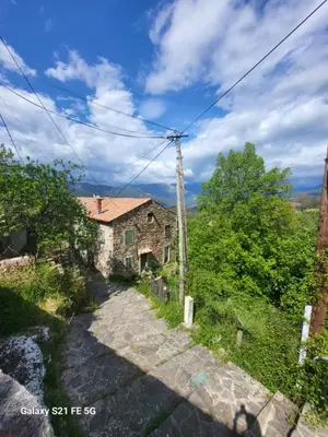 an old house on a hill with a road at Maison avec spa aux portes d'Ajaccio in Carbuccia