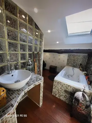 a bathroom with a sink and a bath tub at Maison avec spa aux portes d'Ajaccio in Carbuccia