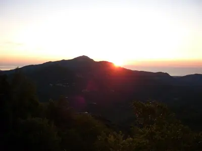 a sunset on a mountain with trees in the foreground at Casa Valentini in Quercitello