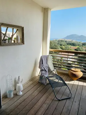 a rocking chair on a porch with a view at Appartement 74 cita Di sali in Porto-Vecchio
