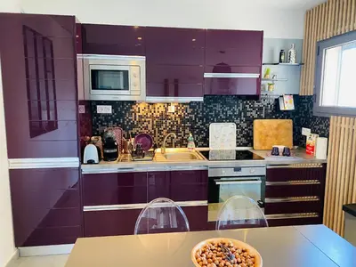 a kitchen with purple cabinets and a bowl of food on a table at Appartement 74 cita Di sali in Porto-Vecchio