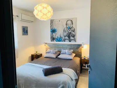 a bedroom with a bed and a painting on the wall at Appartement 74 cita Di sali in Porto-Vecchio