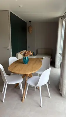 a dining room with a table and white chairs at Bungalow de charme près de Santa Giulia in Porto-Vecchio