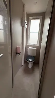 a bathroom with a toilet and a window at Bungalow de charme près de Santa Giulia in Porto-Vecchio