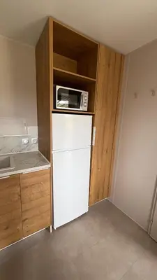 a kitchen with a white refrigerator and a microwave at Bungalow de charme près de Santa Giulia in Porto-Vecchio