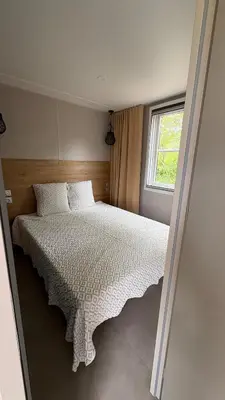 a bedroom with a large bed with a window at Bungalow de charme près de Santa Giulia in Porto-Vecchio