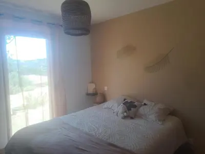a teddy bear sitting on a bed in a bedroom at Nouveau villa T4 à Sotta entre mer et montagnes in Sotta