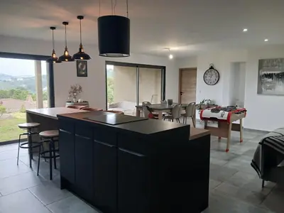 a kitchen and living room with a table and chairs at Nouveau villa T4 à Sotta entre mer et montagnes in Sotta
