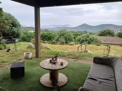 a patio with a table and a couch at Nouveau villa T4 à Sotta entre mer et montagnes in Sotta
