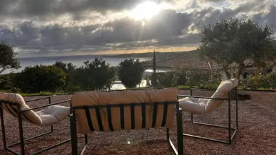 two chairs sitting on top of a hill with the sun at Appartement vue mer Vulpaghja 01 in Cargèse