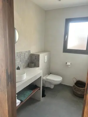 a bathroom with a white sink and a toilet at Appartement vue mer Vulpaghja 01 in Cargèse
