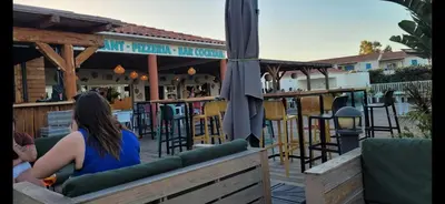 a woman sitting on a bench at a bar at Casa Giul' Poggio Mezzana in Poggio-Mezzana