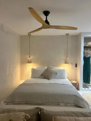 a bedroom with a bed with a ceiling fan at Appartement vue mer Volpaghja 02 in Cargèse