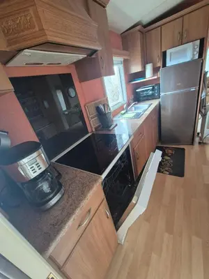 a kitchen with wooden cabinets and a stove top oven at Casa à leccia in Rapale