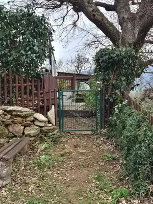 a gate with a bench in front of a fence at Casa à leccia in Rapale