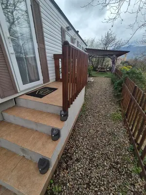 a front porch of a house with a wooden staircase at Casa à leccia in Rapale