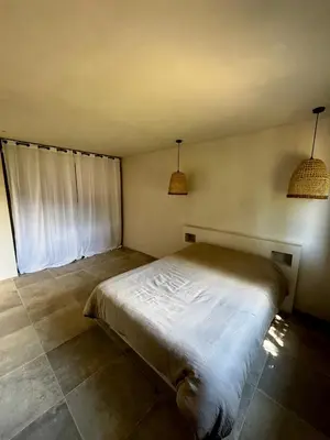 a bed in a room with two pendant lights at Rez-de-villa 65m2 in Propriano