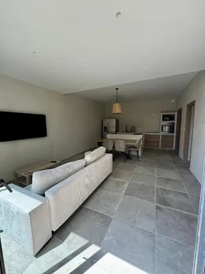 a living room with a couch and a table at Rez-de-villa 65m2 in Propriano