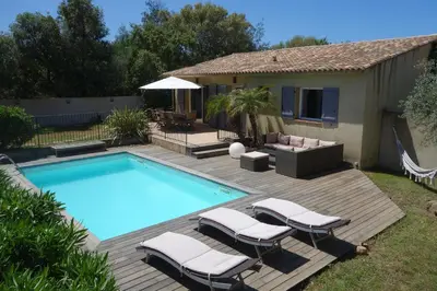 a swimming pool with lounge chairs next to a house at Villa Morticcione in Zonza