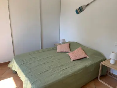 a green bed with two pillows on it in a room at Villa Morticcione in Zonza