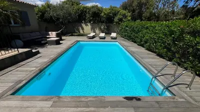 a swimming pool with blue water in a yard at Villa Morticcione in Zonza