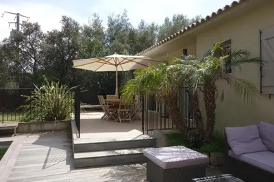 a patio with a couch and an umbrella at Villa Morticcione in Zonza