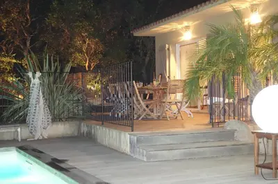 a porch of a house with a bench and a table at Villa Morticcione in Zonza