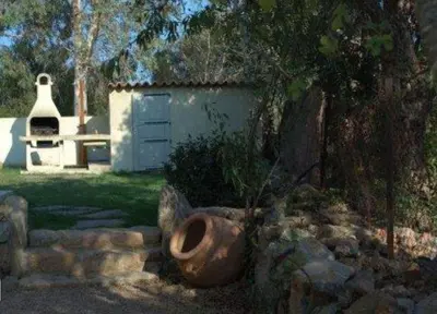 a garden with a large pot in front of a building at Villa Morticcione in Zonza