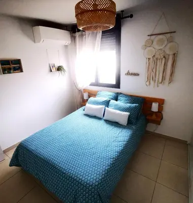 a bedroom with a bed with blue sheets and a window at Appartement T2 à Porto-Vecchio in Porto-Vecchio