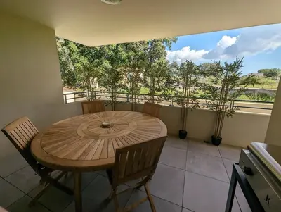 a table and chairs in a room with a large window at Appartement neuf près du port de Porto Vecchio in Porto-Vecchio